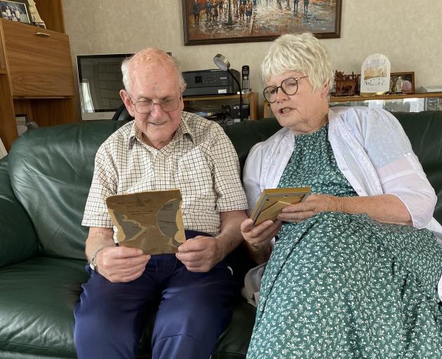 Noel Dickel and Faye Ormandy look at the photo of the 1921 relay team wearing their medals. PHOTO...