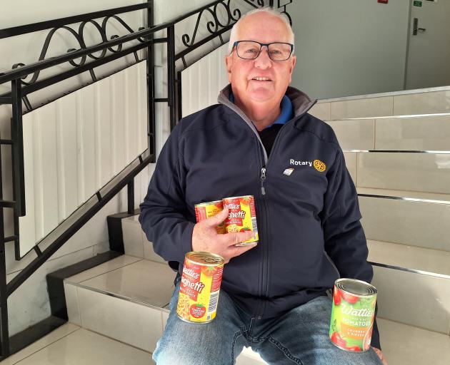 South Island Rotary district governor Dave McKissock is ready to collect cans of food for project...