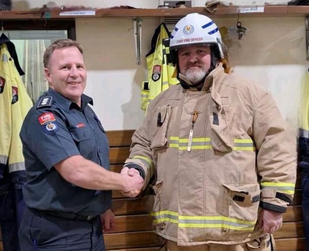Mark Eales is congratulated on getting his white chief fire officer hat for the Tapanui Fire...