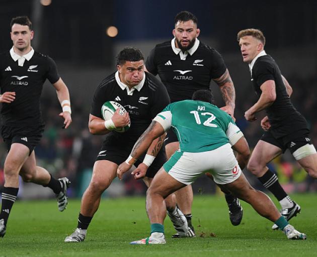 Tamaiti Williams braces for a tackle from Ireland's Bundee Aki during an All Blacks test in...