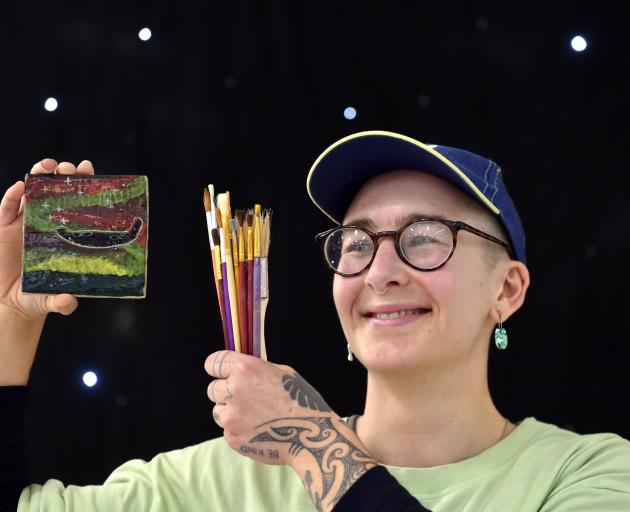 Dunedin artist Jess Nicholson holds one of their clay tiles after the workshop at New Zealand...