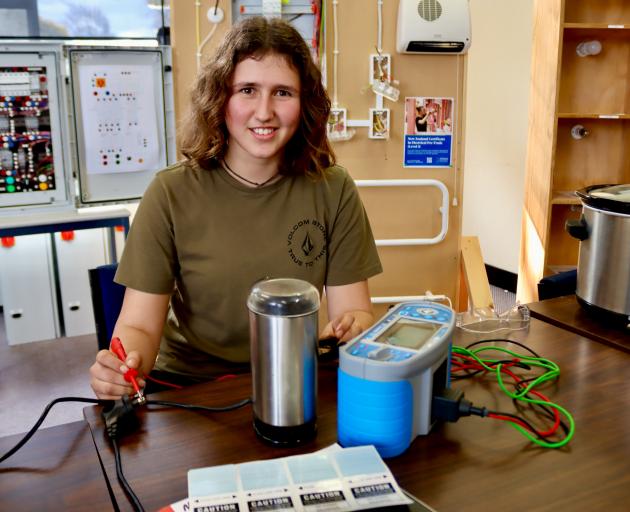 Otago Polytechnic student Sienna Collins uses a multi-function tester to test connections on a...