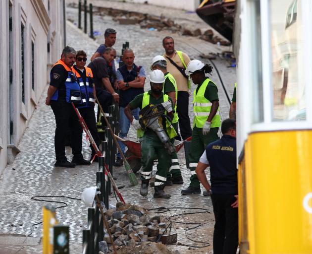 People work at the site of the accident after Gloria funicular railway car, a popular tourist...