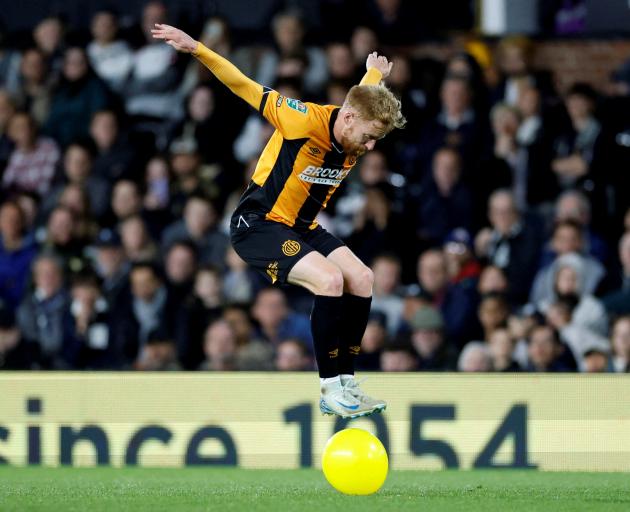 Cambridge United’s James Brophy jumps on a balloon during a League Cup game against Fulham at...