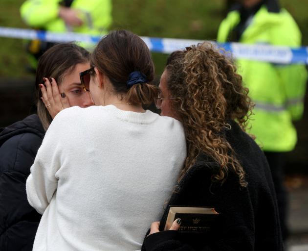 People react near the scene after an incident in which a car was driven at pedestrians and a...