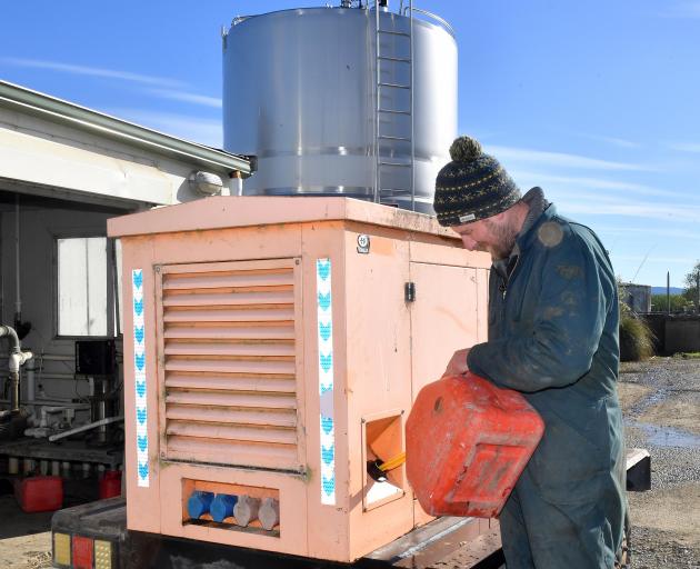 Josh Adam refuels his generator at his Taieri dairy farm. Photo: Stephen Jaquiery