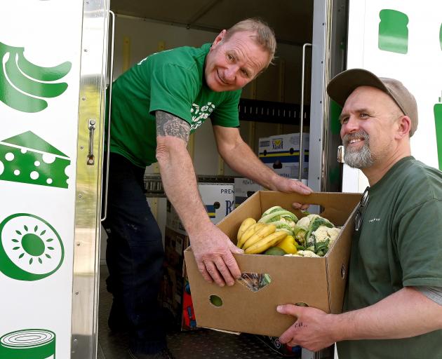 KiwiHarvest Dunedin operations co-ordinator Darryn Graves (left) hands over food to PSO food bank...