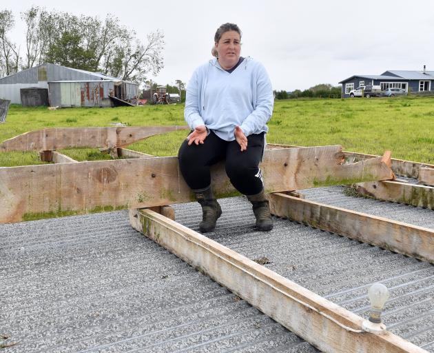 Inch Clutha farmer Donna Weir sits on the roof of her shed that was sent flying about 100m during...