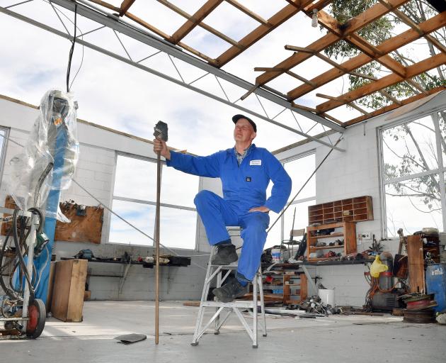 Concord Garage owner Barry Gordon has his feet up as no roof means no work. PHOTO: STEPHEN JAQUIERY