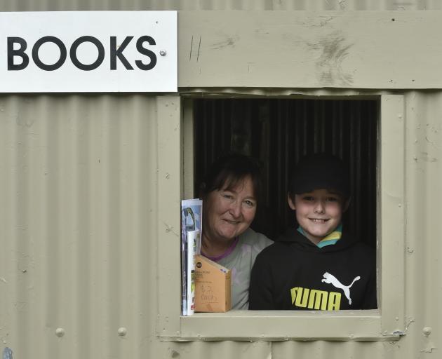 Jeanine Coleman and Ethan Barry, 11, both of Alexandra, are in charge of the race books window....