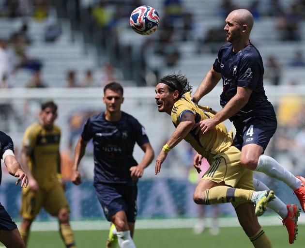 New South Island United signing Christian Gray wins a header over Uruguayan striker Edinson...