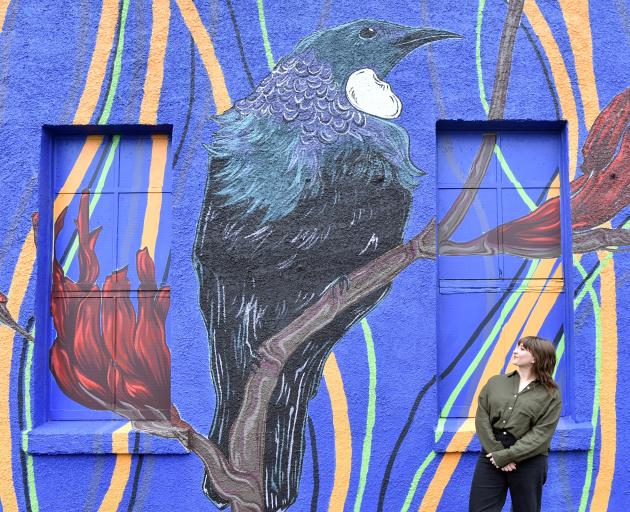 Artist Lara Hattingh is dwarfed by a new resident of Rankeilor St, South Dunedin — a tūī perched...