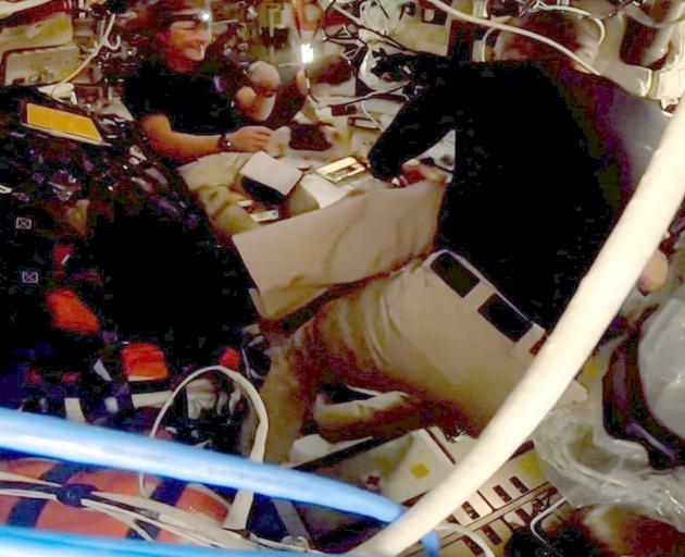 The crew works in the confined space of the capsule.