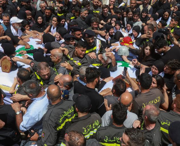 Mourners attend the funeral of Lebanese civil defence members, who were killed in an Israeli...