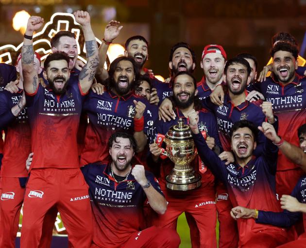 Jacob Duffy, behind Virat Kohli (with arms raised), and the Royal Challengers Bengaluru team...