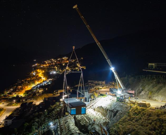 A home prebuilt in Christchurch is craned on to a steep Queenstown section at nighttime recently....