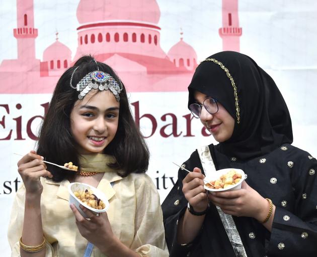 Khirad Ahmed, left, and Fatima Ali, both aged 10, enjoy some of the food.