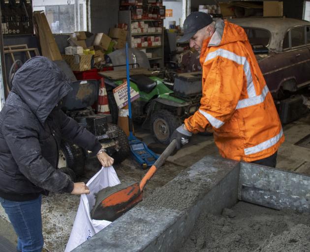 Doyleston residents fill sandbags to help keep the water out of their homes. Photo: Geoff Sloan