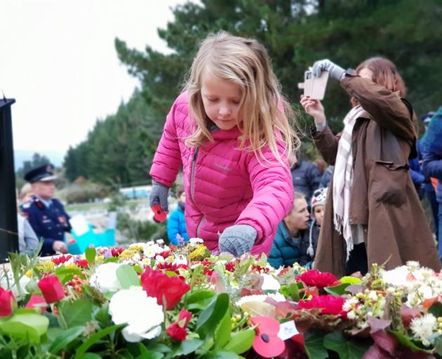 Mikayla Clark (7), of Lake Hawea, lays a poppy on the Hawea Memorial at her first dawn service....