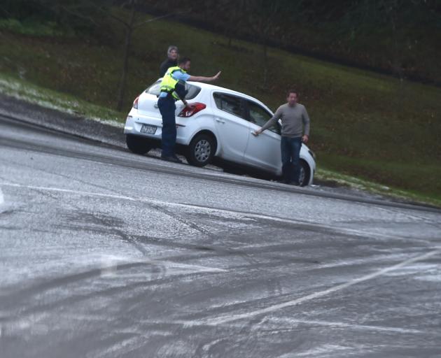 Police assist a driver who slid off the road due to the icy conditions in City Rd this morning....