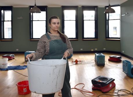 George Street Tattoo manager Molly van Dijk stands with a bucket in a first-floor room full of...