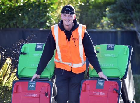 Dunedin City Council contractor Vincenz Binder helps deliver the new council recycling bins in St...