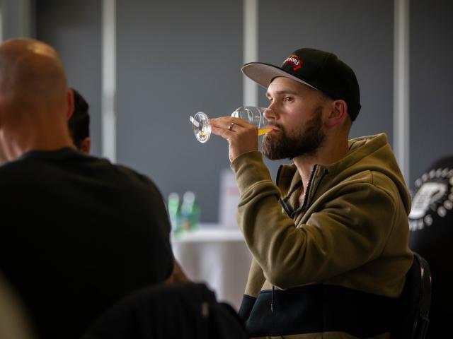 Mason Pratt, Emerson’s senior brewer, blind taste tests an entry during the awards’ judging.