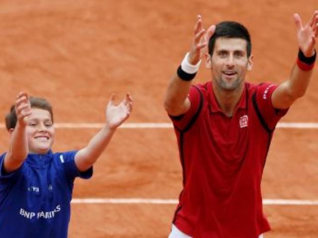 Novak Djokovic celebrates his victory with a ball boy. Photo Reuters