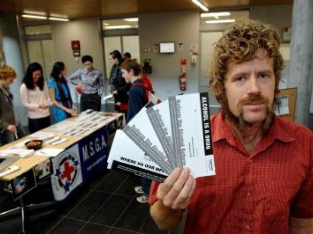 University of Otago student Stefan Fairweather, who is a member of the group Medical Students for Global Awareness (MSGA), yesterday holds postcards urging stronger measures to counter binge drinking. Photo by Linda Robertson.