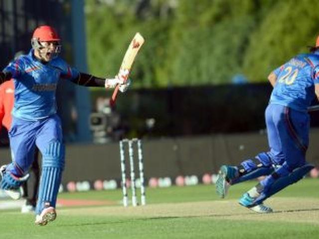 Afghanistan's Hamid Hassan (left) celebrates while Shapoor Zadran sets off on a victory dash after hitting the winning runs to seal a dramatic World Cup win against Scotland at the University Oval yesterday. Photo by Peter McIntosh.