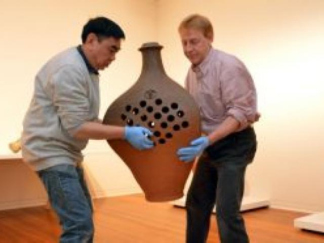 Dunedin Public Art Gallery preparator Russell Soo (left) and senior preparator Andrew Geros move the Barry Brickell work Triple tube plate (steam series) in the gallery yesterday. Photo by Stephen Jaquiery.