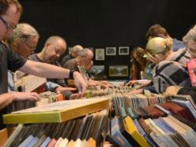 Jeremy Tallent (front left) and Kevin White (front right) join the throng on the stage at the Regent Theatre's Anything But Books Sale yesterday as they browse the  record albums. Photo by Peter McIntosh.