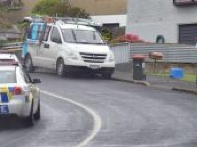 Police talk to  three occupants of a vehicle which allegedly reached speeds of more than 170kmh in Dunedin yesterday. Photo by Stephen Jaquiery.