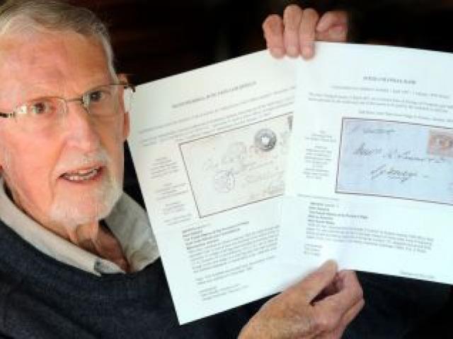 Stamp collector Greg Francis with copies of two items he  sold in a London auction recently. Photo by Craig Baxter.