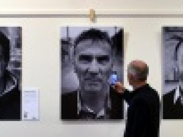 Using his cellphone, Phil King, of Wellington, takes a photo of his brother Steve King, of St Clair, who appears in the ‘‘People of South Dunedin’’ exhibition at the Community Gallery. Among the community identities photographed are (from left) Br