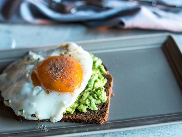 Grainy toast and avocado topped with an egg. Photo: Getty Images