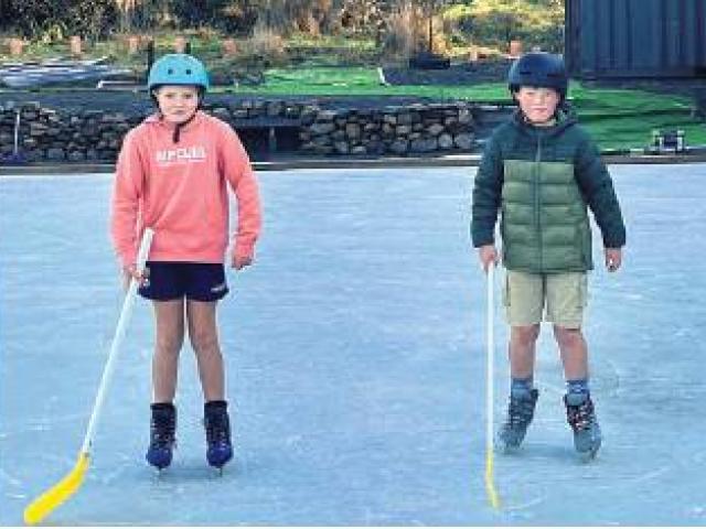 Honor Coleman, 10, and Thomas Mee, 10, try out ice hockey sticks at the Staveley rink. PHOTO...