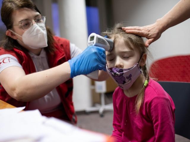 At a temporary shelter in Zilinia, Slovakia a volunteer takes an 8 year old Ukrainian refugee’s...