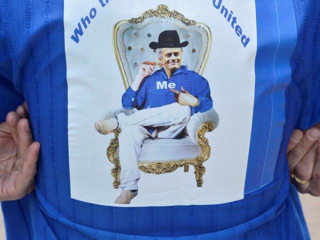 A Chelsea supporter wears a shirt bearing a picture of Jose Mourinho, outside Chelsea's Stamford...
