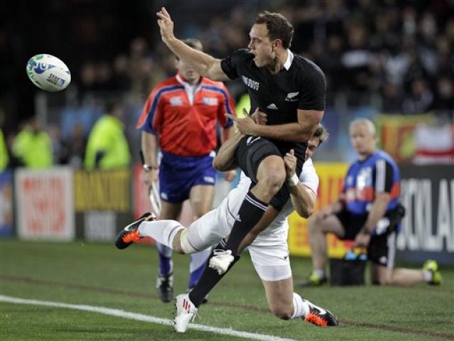 Israel Dagg passes the ball as he is tackled by France's Alexis Palisson. (AP Photo/Themba Hadebe)
