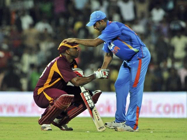 India's Irfan Pathan (R) speaks with West Indies' Kieron Pollard after Pollard was out for 119 in...