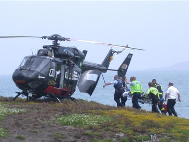 Rescuers carry an ill Kakanui man to the Otago Regional Rescue Helicopter on the island at the...