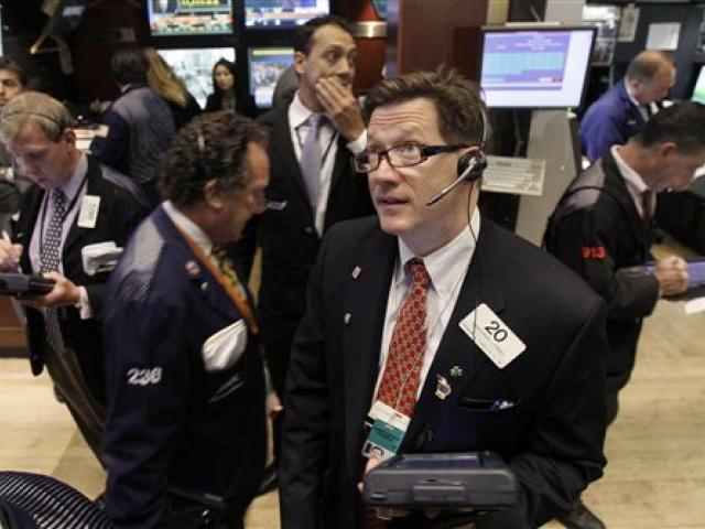 Trader Christopher Forbes watches prices as he works on the floor of the New York Stock Exchange...