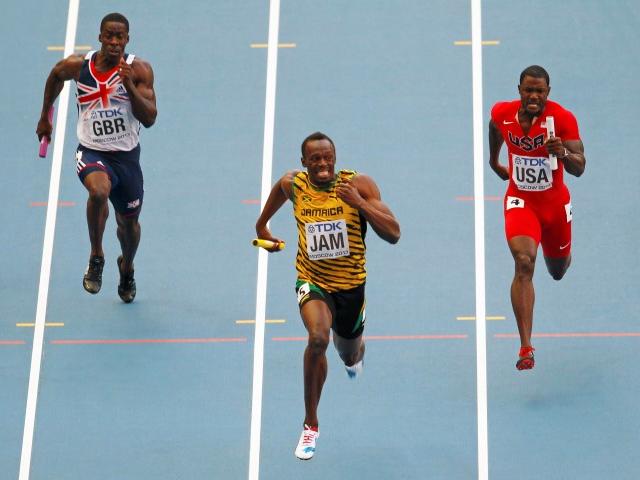 Usain Bolt of Jamaica (C) sprints to the finish line ahead of Dwain Chambers of Britain (L) and...