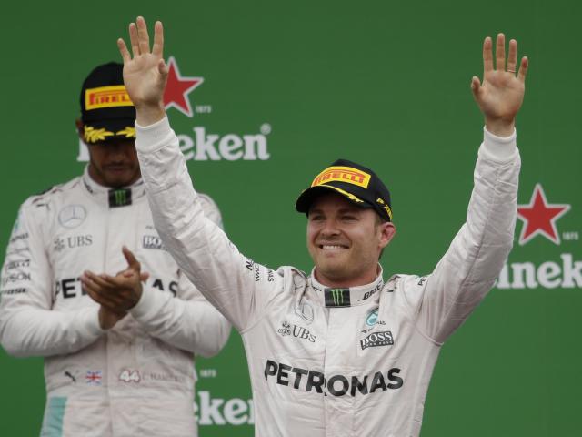Nico Rosberg celebrates his win on the podium after the race as Lewis Hamilton looks on. Photo:...