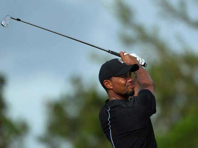 Tiger Woods hits his tee shot on the 12th hole during round one of the Hero World Challenge at...