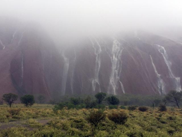 Waterfalls cascade down Uluru after heavy rain. Photo: Reuters