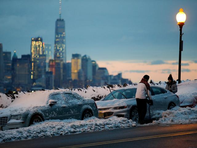 Residents clear their cars and street of snow in Weehawken, New Jersey, as the One World Trade...