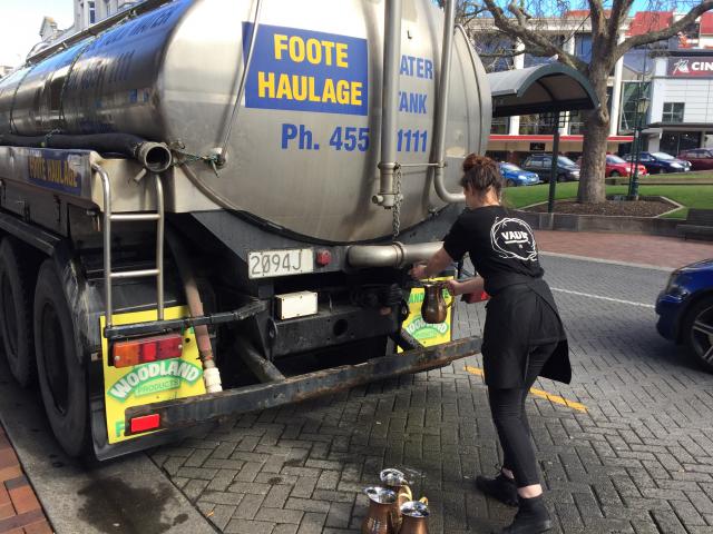 A hospitality worker gets water from a water tanker in the Octagon. Photo: Chris Morris