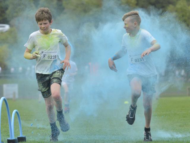 Izak Wilson (12) and Mitchell Wheeler (12), both of Dunedin, run through a cloud of blue dye on...